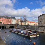 a boat traveling down a river next to a bridge